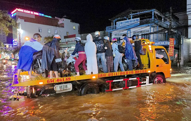 Nhiều tình nguyện viên hỗ trợ người dân khi xe bị chết máy do triều cường và mưa lớn